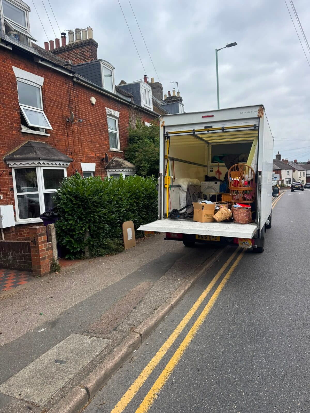 RayMovals removal van loaded with a full house move, tail-lift down outside a red-brick terraced house