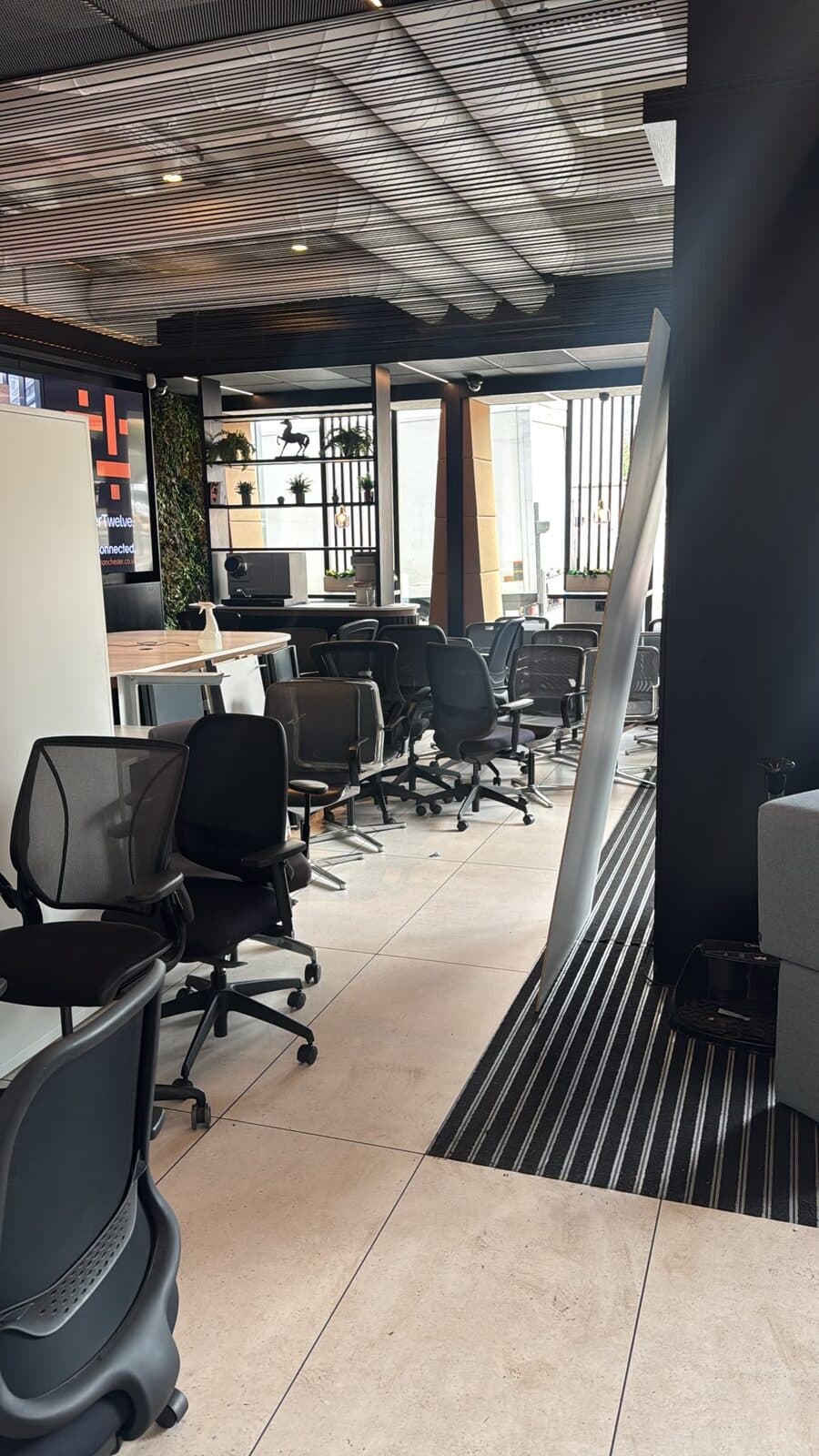 Rows of mesh task chairs and desks installed across the open-plan floor of the A6 Motors office