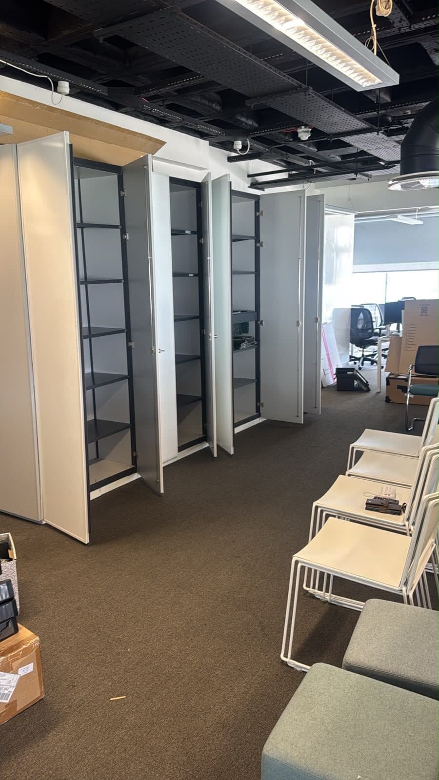 Tall office storage units positioned along the wall with stacking chairs staged alongside