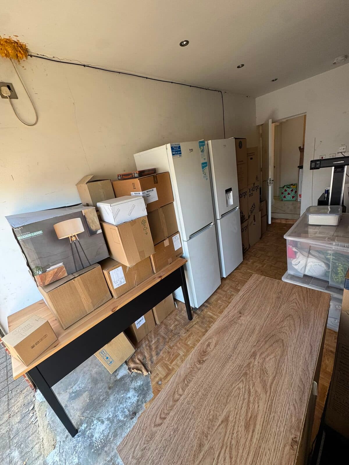 Fridge freezer, console table and packed boxes ready for collection on the Luton two-bedroom move