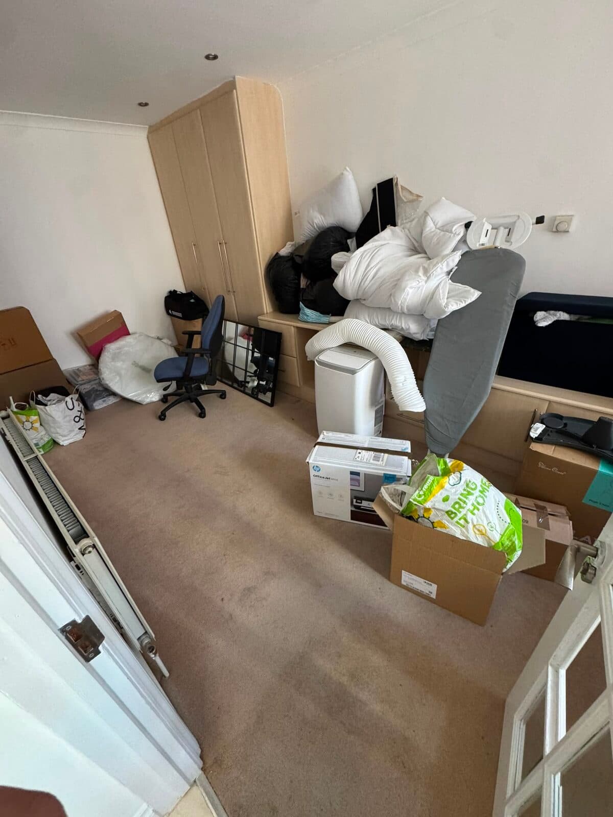 Bedroom packed down with soft furnishings and boxes ready for the move to Harrow