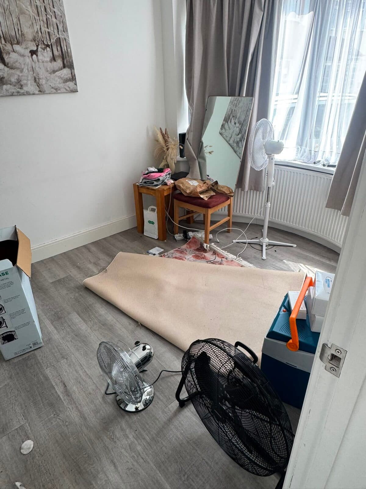 Bedroom being cleared during the Uxbridge house move, rug rolled back and furniture pulled away from the walls