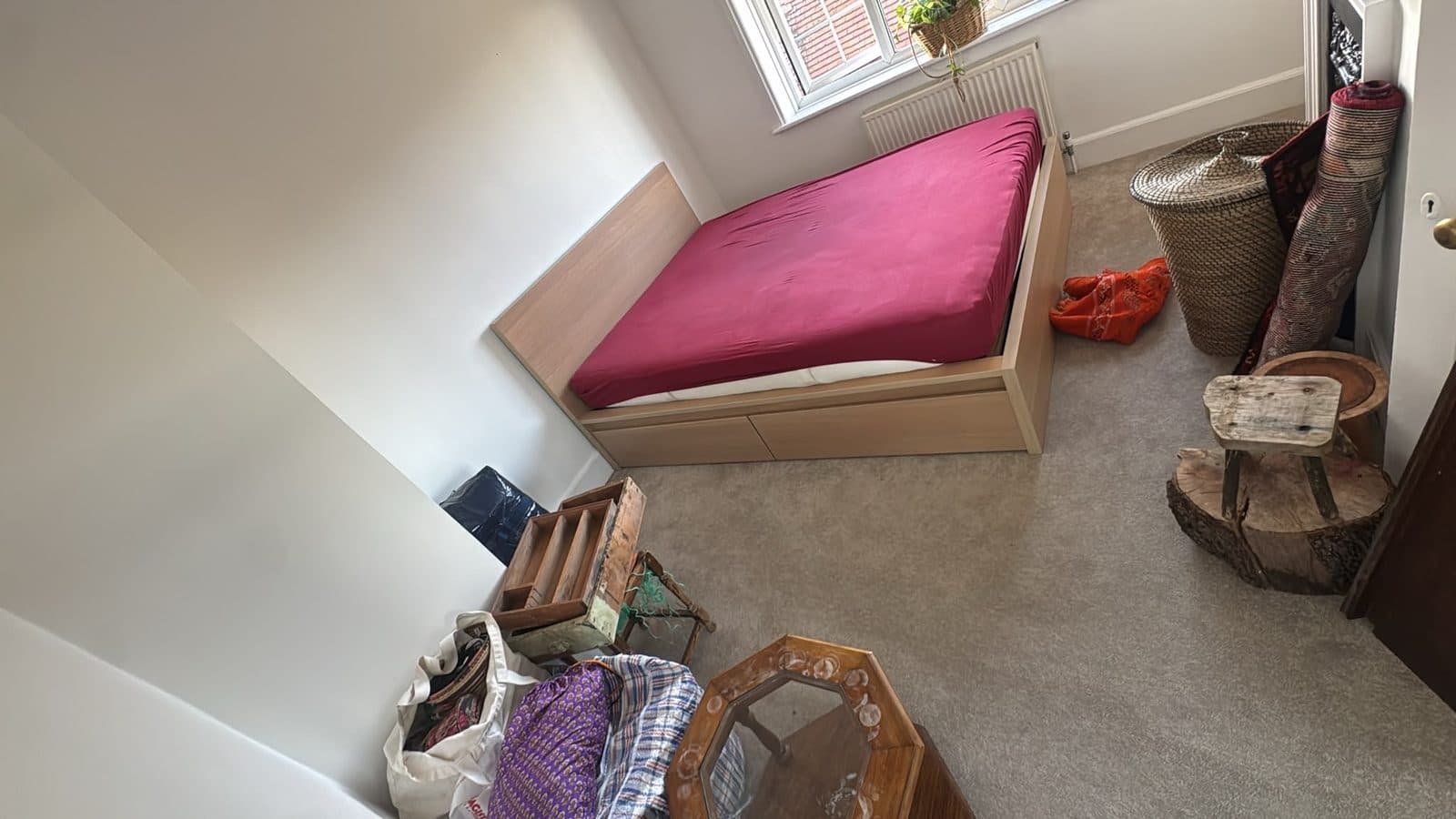 Bed frame in a sloped-ceiling bedroom being prepared for dismantling