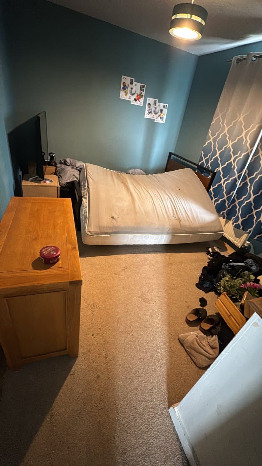 Mattress lifted clear of the frame in a bedroom before the bed was taken apart
