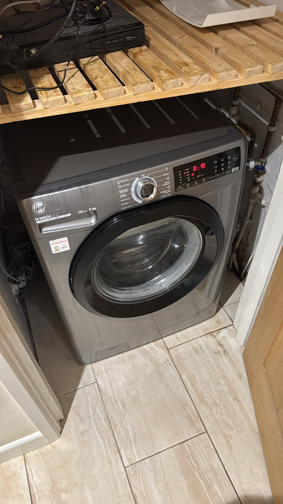 Washing machine reconnected and plumbed back in under the worktop at the Bedford bungalow