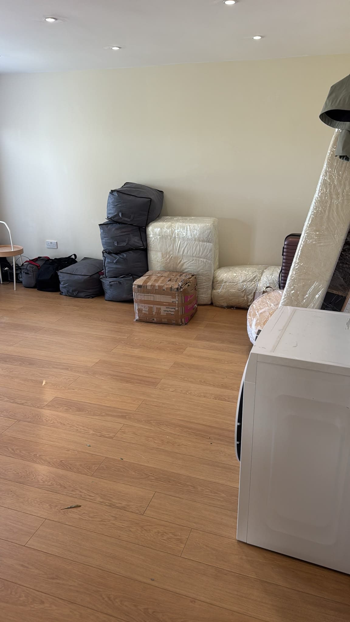 Wrapped mattresses, bagged bedding and appliances staged for loading during the house move