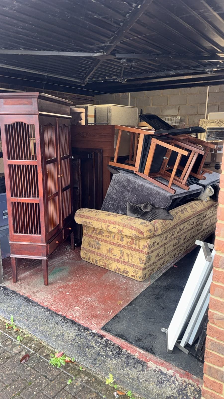Garage filled with wardrobes, sofas, tables and mattresses stored at the Gamlingay property